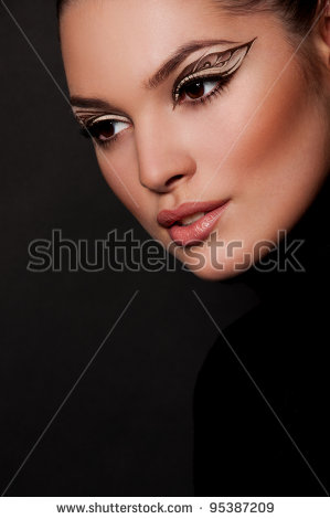 pretty brunette woman with creative makeup on black background - stock photo