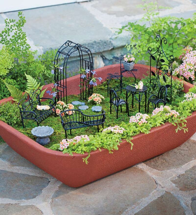 This Fairy Garden starter kit from Plow &amp; Hearth comes with a self-watering container and miniature furniture to get you started.这个花园小景居然配备了自动浇水器哦