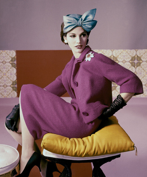 A model wears a fuscia dress suit and hat with bow detail by Emme, 1961. #Vogue 365