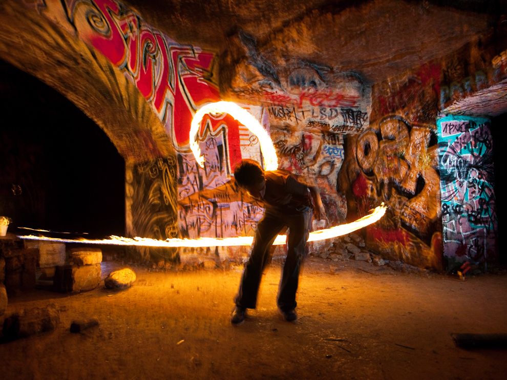 In Paris, old limestone quarries fan out in a deep and intricate web under many neighborhoods, mostly in the southern part of the metropolis. Here, a fire thrower named Louis spins light at a gathering in one old quarry. Nearly all of the more than 180 miles of quarry tunnels are off-limits, but par