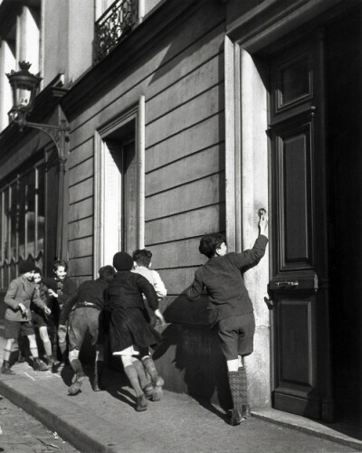 1934年，一群孩子在街边恶作剧。 Photo by Robert Doisneau