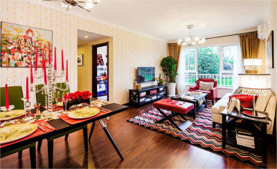 客厅也是色彩的。地毯、挂画、背景墙，最出彩的是桌子上的玻璃烛台和红色的蜡烛。