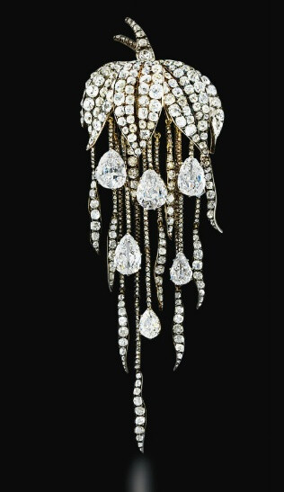 A SUPERB ANTIQUE DIAMOND BROOCH Of naturalistic design, the pavé-set old-cut diamond leaf canopy suspending a graduated fringe of diamond trails with six pear-shaped diamond drops, mounted in silver and gold, brooch circa 1860, diamond drops late 18th century, 12.7 cm long