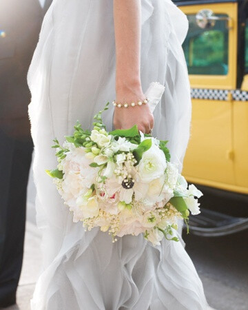 White Wedding Bouquet This elegant bouquet abounds with freesia, anemones, lilies of the valley, peonies, ranunculus, tulips, and verdant hosta leaves.