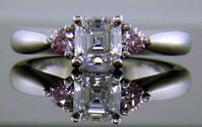 An Asscher-cut diamond set with two Fancy Intense Pink diamonds in a hand-crafted platinum ring.