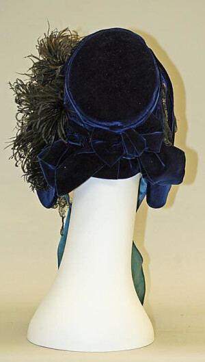 Bonnet 1861, American, Made of silk and ostrich feathers ~The look of demure prim gentility was emphasized by the loss of the great hats in 1835 for bonnets. Great hats had given a flirtatious air to clothes and their replacement by bonnets changed the whole character of day dresses.