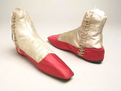 Shoes, c. 1830-50. White and cerise satin over linen. Narrow square toes with cerise toe-caps. Side opening with white cord tagged laces. Tongue lined with cerise. Sole thickened at heel.