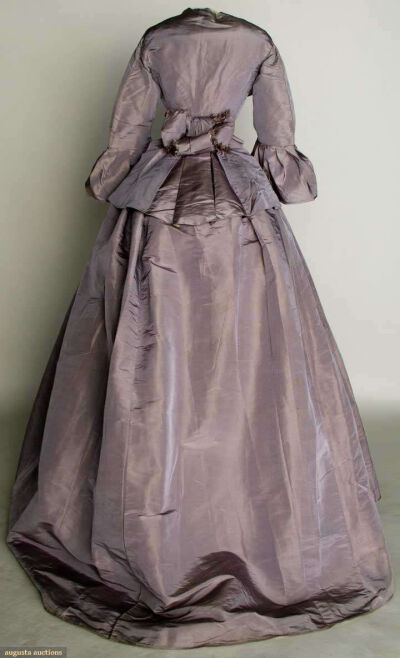 LILAC SILK DAY DRESS, EARLY 1860s 2 piece faille, peplum bodice, trained skirt, B 36", W 21.5", L 41"-57", (light skirt stains, water stains on peplum, alterations, sleeve flounce basted on) very good…