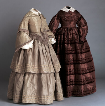 From left: Dress (bodice and skirt), early 1860s American Silk taffeta and fringe, cotton undersleeves and cotton lace collar Gift of Sarah Robbins and Dottie Brown, 1990.c.38.A–B Dress, 1865 …