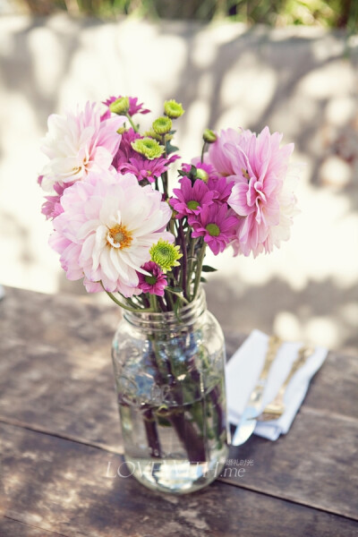 纸风车在婚礼中熠熠生辉，大丽花和小雏菊拼凑成桌花，梅森瓶作为饮料器皿，让这个婚礼格外清新！