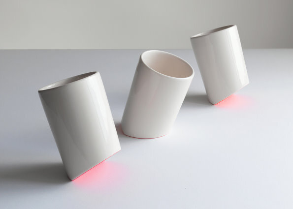 Royal College of Art graduate Bilge Nur Saltik has designed a collection of minimal white plates, bowls and cups that tip backwards and forwards, revealing a flash of fluorescent pink on their undersides