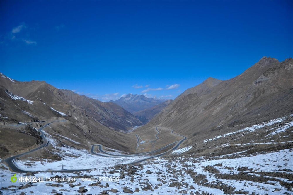 蓝色天空背景下的天山雪峰上蜿蜒的公路图片素材