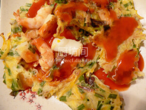 【韩式海鲜煎饼】 做法：  1、面粉1杯、澄粉（淀粉）1/2杯、鸡蛋1个、盐、胡椒粉适量，加入清水调成稍厚的面糊；用韩国辣酱、柠檬汁、蜂蜜调成蘸酱备用；  2、将虾仁、鱿鱼整理好，洋葱切成粒/丝，年糕条切成小段，小葱切成末；平底锅倒入适量油煸香洋葱，倒入虾仁、鱿鱼快速翻炒至变色；  3、改小火，把海鲜材料均匀铺排在锅底，然后倒入适量面糊与海鲜材料混合，撒上小葱末，转中火煎2、3分钟，同时沿锅边加入1勺食用油，表面不见生面糊后，翻面再煎约1分钟即可盛出；淋上蘸酱即可。