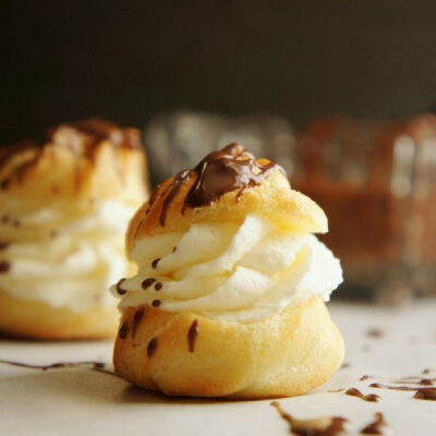 These bite size cream puffs are filled with homemade custard and whipping cream. Then drizzled with chocolate for the ultimate party dessert.