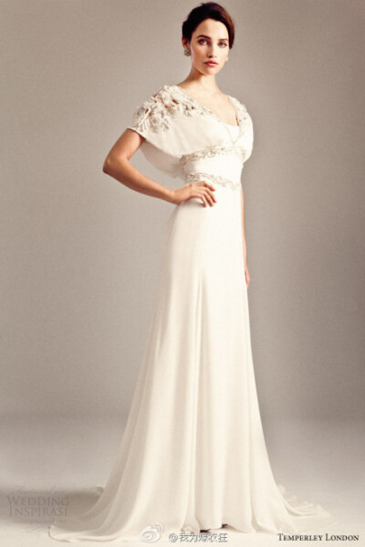 Temperley London 2014系列婚纱，设计师将套装元素引入婚纱，与短款的不规则的裙摆互相搭配，夸张的A字婚纱布满白色玫瑰欧根纱，将模特轻轻包裹。