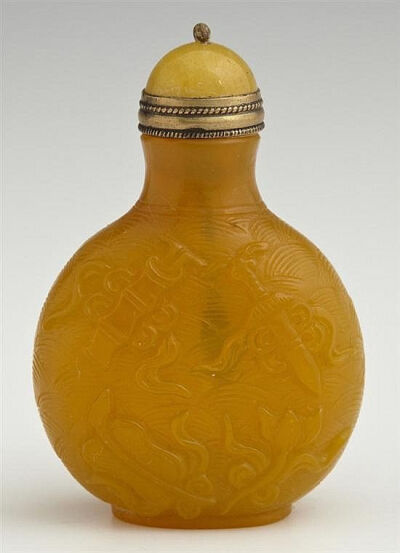 Chinese Egg Yolk Footed Yellow Peking Glass Snuff Bottle, c. 1900, the sides carved with 8 scholar's items in the sky, with a yellow Peking glass stopper, from the Christian collection