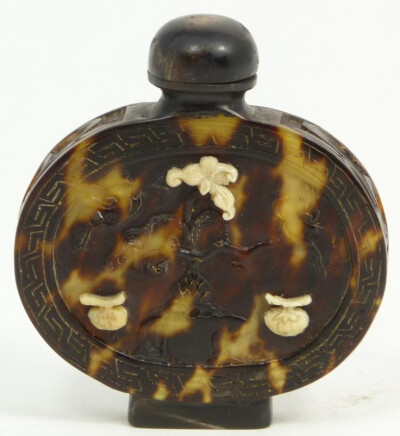 Antique hand carved tortoise shell and ivory snuff bottle. Translucent mottling to shell. Has relief carved designs throughout depicting flowers and fruit. Has ivory overlay fruit and flowers.