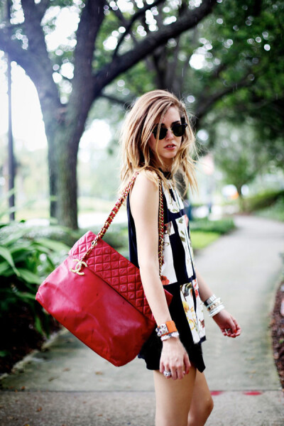 博主嘉拉·法拉格尼 (Chiara Ferragni) 再出山，用菲利林3.1 (3.1 Phillip Lim) Neo-grunge风格T恤搭配Zara不对称裤裙，红色香奈儿 (Chanel) 大号古董包足够为这套“黑漆漆”的搭配增加亮点。