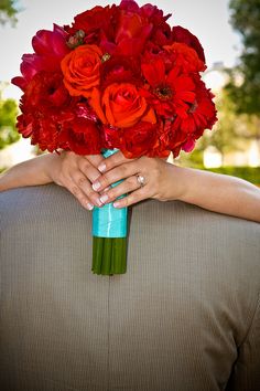 Red roses, red gerbera daisies. I want everything but the roses, for the bridesmaid bouquet. With an orange ribbon.