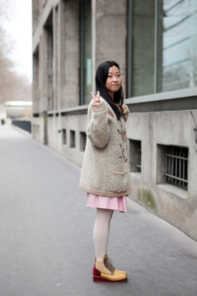 毛茸茸中长款外套搭配粉色小裙子和同样毛绒绒的小短靴，可爱甜美。