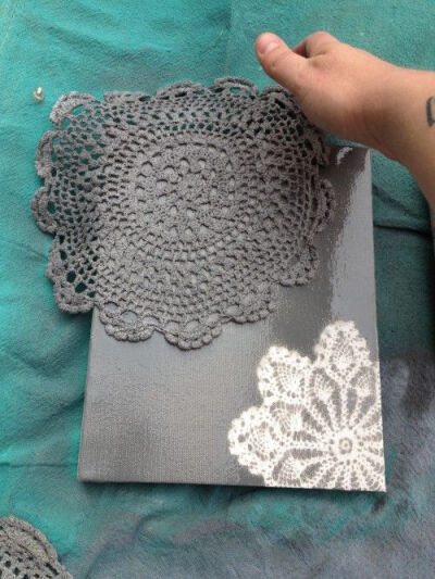 spray paint doilies on canvas or sanded wood