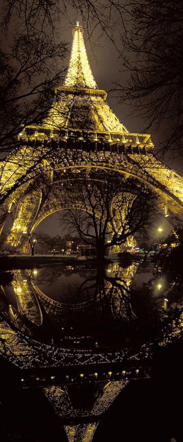 At the foot of Eiffel Tower at night, Paris, by Arnaud Frich