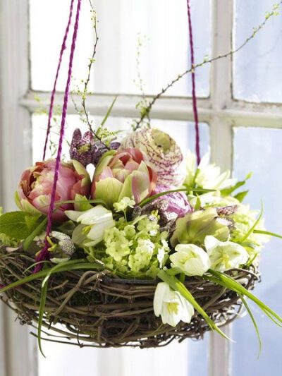 Nest of spring flowers in a hanging wicker basket