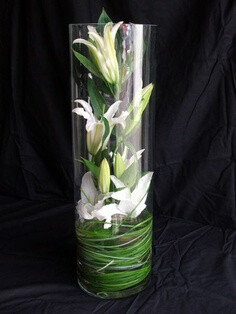 Really cool!!!! Lily grass in the bottom and white lilies down in the clear glass vase.