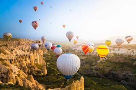 卡帕多西亚（Cappadocia），位于土耳其中部的卡帕多西亚以其童话般的斑点岩层而闻名：奇特的岩石构造、岩洞和半隐居人群的历史遗迹令人神往。很多地方都可以乘坐热气球,但卡帕多西亚一定是最奇特的。每天，随着太阳的升起，数以百计的热气球开始带着游客们光顾这片土地，形成这些壮观的景象...