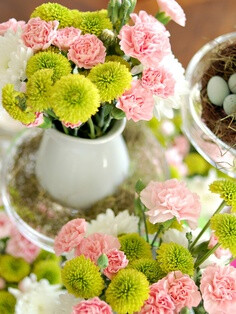 carnations and button mums. use red carnations with pink button mums and an olive green ribbon around the vase