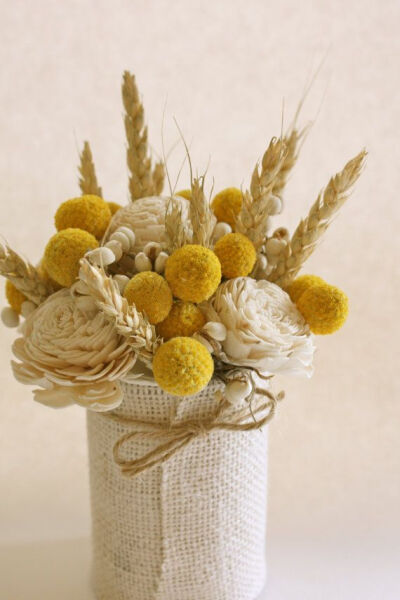 MIlk and Honey Centerpiece - An upcycled tin can wrapped with white burlap and accented with a natural twine has been filled with craspedia, sola roses, tallow berries, and rye. Arrangement stand abou…