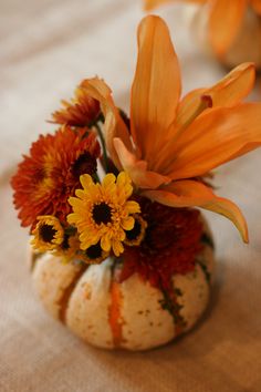 Interesting accent idea... -white and orange pumpkin flower arrangement