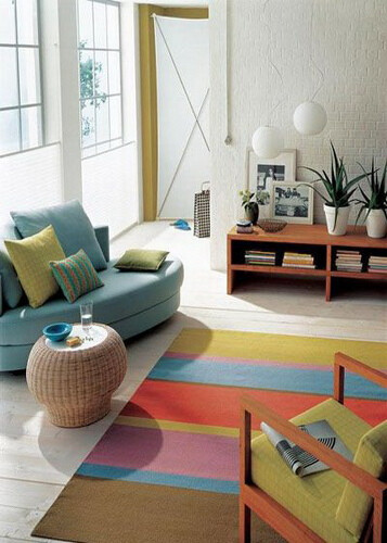 不要被传统的思维绊住了脚，小小的沙发也能打造出不凡的客厅空间。选用圆滑边角的小双人位沙发(直角的沙发或许就没有这样的效果)，留出大片活动空间。沙发上层层叠叠的抱枕和地面上多彩条纹的地毯，都让这个小客厅充…