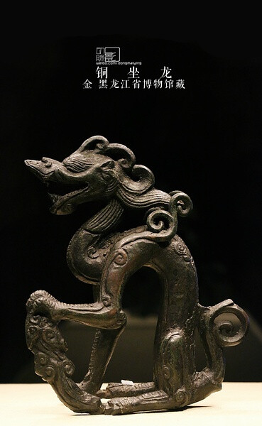 2013.11.3 首都博物馆 白山黑水海东青展 金 铜坐龙 黑龙江省博物馆镇馆之宝.出土于哈尔滨市阿城区白城金上京会宁府遗址.龙呈踞坐式,铜质,龙首张口,肩微前弓,左腿翘起,与左后肢间有腾云相连.尾部翘起外卷,前肢长鬣突出于肩部之上,与头上卷鬣及后扬的长