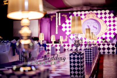 整场婚礼以紫色+金色为主，大到舞台，迎宾区的设计，小到纸巾的选择，我们都大胆的将“菱形格”元素充分融入其中。舞台和T台我们也都以大面积的“菱形格”代替了以往的白色地毯，使原有的婚礼现场更会让宾宾客觉得有…