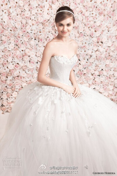 Georges Hobeika 2014春夏婚纱系列，粉色玫瑰花的背景墙为系列婚纱注入了新的浪漫主义色彩，轻盈的薄纱与淡淡的色彩之间，满足新娘们对梦幻婚纱的想象。