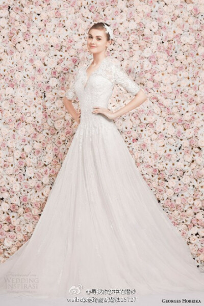 Georges Hobeika 2014春夏婚纱系列，粉色玫瑰花的背景墙为系列婚纱注入了新的浪漫主义色彩，轻盈的薄纱与淡淡的色彩之间，满足新娘们对梦幻婚纱的想象。