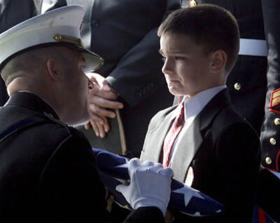 30】一名小男孩在其父亲的葬礼上哭泣，其父亲战死于伊拉克战争中。