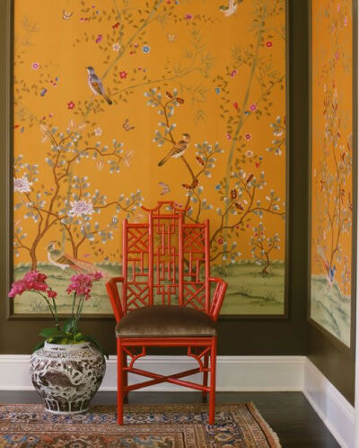 Chinoiserie wallpaper in apricot with black molding and a Chinese red chair.