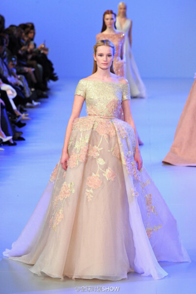 Elie Saab（艾丽·萨博）2014春夏系列高级定制时装，Elie Saab将五颜六色的花朵汇聚到了以渐变色为底色的裙装上，加上模特走动时摆动的裙摆效果，让整套礼服恰似正在生动地上演着一场从天空飘洒下的花雨。