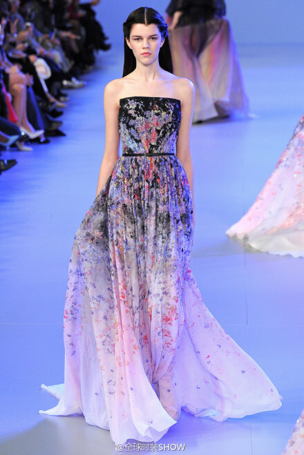 Elie Saab（艾丽·萨博）2014春夏系列高级定制时装，Elie Saab将五颜六色的花朵汇聚到了以渐变色为底色的裙装上，加上模特走动时摆动的裙摆效果，让整套礼服恰似正在生动地上演着一场从天空飘洒下的花雨。