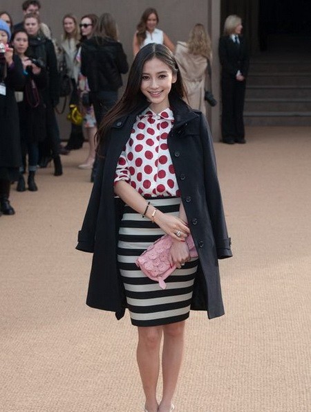 Angelababy 英国伦敦当地时间2014年2月17日，杨颖(Angelababy)助阵 Burberry Prorsum 伦敦2014秋冬时装周专场秀。标准的甜美公主笑容让这身造型每个细节都透露出调皮感，也让大衣造型年轻不少。