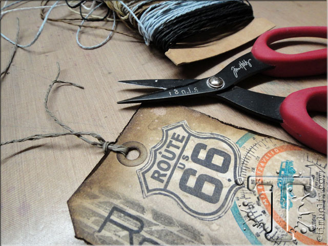 step 32: attach a piece of paper string through the top of the tag to mimic an old travel baggage tag.