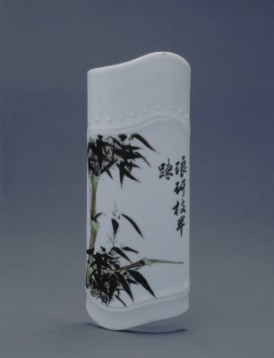 墨彩竹节式臂搁，清康熙，长17.2cm，宽6.9cm。清宫旧藏。 臂搁长方形，上下等宽，通体施白釉，正面上下两道竹节纹之间以墨彩绘竹叶图，画旁题有“琅玕枝半疏”五言诗句。画面上端竹节外凸饰鼓钉一周。 臂搁…