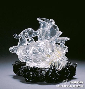 水晶凫式砚水壶，清，高4.6cm，长12.5cm。清宫旧藏。砚水壶白色透明水晶质。运用圆雕、浮雕和镂雕工艺塑造凫鸟和灵芝造型。凫身中空，背部有开口，灵芝内凹。其造型寓多福多寿之意。