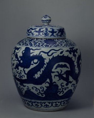 明嘉靖 青花云龙纹“寿”字盖罐，明嘉靖，通高54.2cm，口径25.2cm，底径30cm。 罐圆口，方唇，溜肩，肩下渐敛，平底。盖面隆起，盖顶置宝珠形纽。罐里光素无纹饰，外部青花装饰。肩绘缠枝莲纹。盖和腹部均绘双…