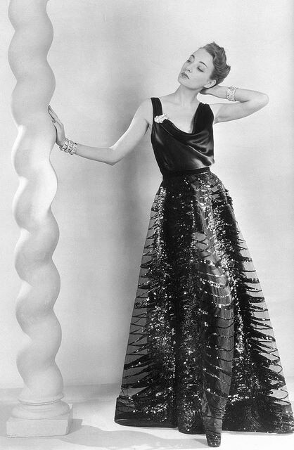 ~Liz Gibbons in black satin slip evening dress with net overlay embroidered in paillettes by Vionnet, jewelry is aquamarine ring and diamond clip and bracelets by Tiffany, photo by Martin Munkacsi, Harper's Bazaar, Nov. 1937~