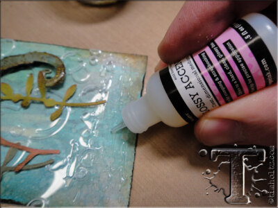 step 42: apply a thin layer of glossy accents to the area of the tag you want to adhere the “sand” mixture to.