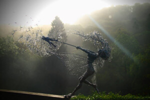 英国雕塑家Robin Wight把不锈钢丝缠绕在一起，然后将打造成仙女抓住蒲公英的造型。