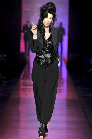 Jean Paul Gaultier SS2012 Couture。Gaultier 成功地将他的高级时装发布变成了Amy Winehouse的欢送会，并为他美丽而怪异的服装增添了色彩艳丽的一笔。并且Gaultier 设计的用披肩包住一边的细条纹西装夹克、珠饰细腿…